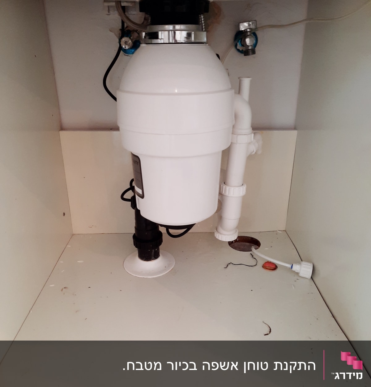 מתקן טוחן אשפה מתחת לכיור עם צינורות חיבור